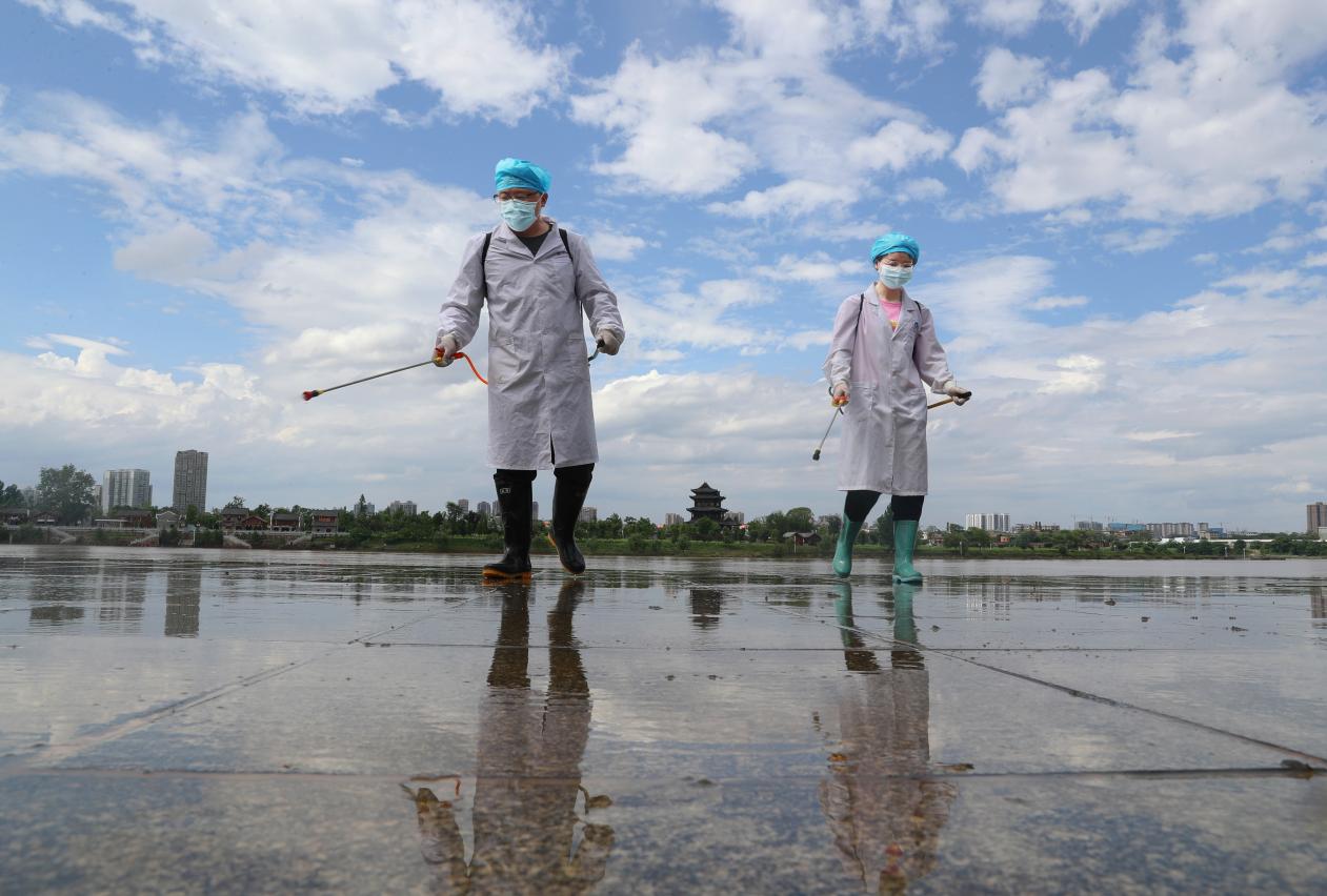 2021年5月26日。在湖南省衡阳市雁峰区千吨级码头沿江风光带，伟德国际victor1946公共卫生学院的党员志愿者在给清除淤泥后的地方举行消毒。  (2)